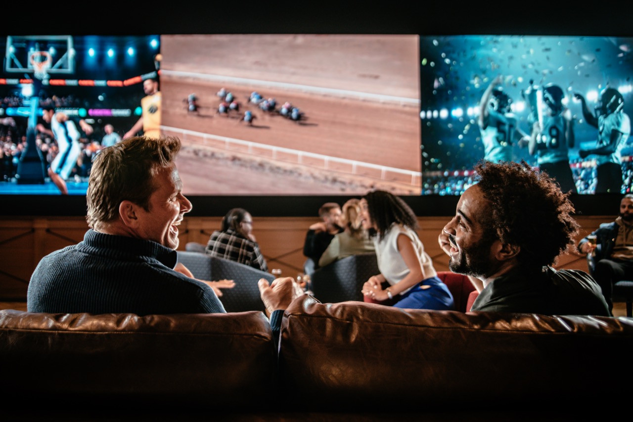Guests seated in a lounge watch horse racing and sports on large screens at Owensboro Racing & Gaming